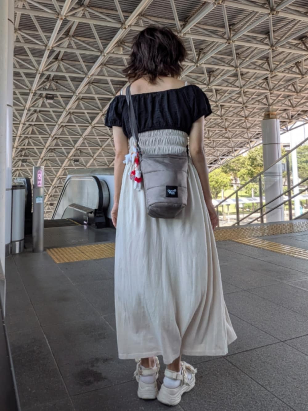 ベージュ系のワンピース、ブラック系のその他トップス、グレー系のショルダーバッグを着用したレディースの夏コーディネートの2枚目の写真
