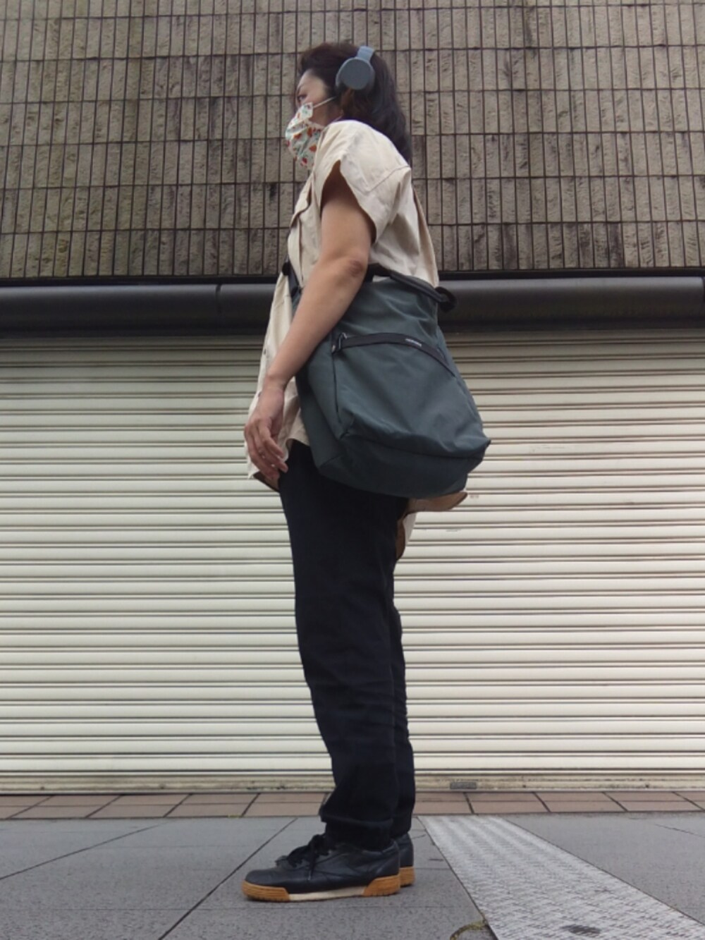 ベージュ系のTシャツ/カットソー、ブラック系のスラックス、ブラック系のスニーカーを着用したレディースの夏コーディネートの2枚目の写真