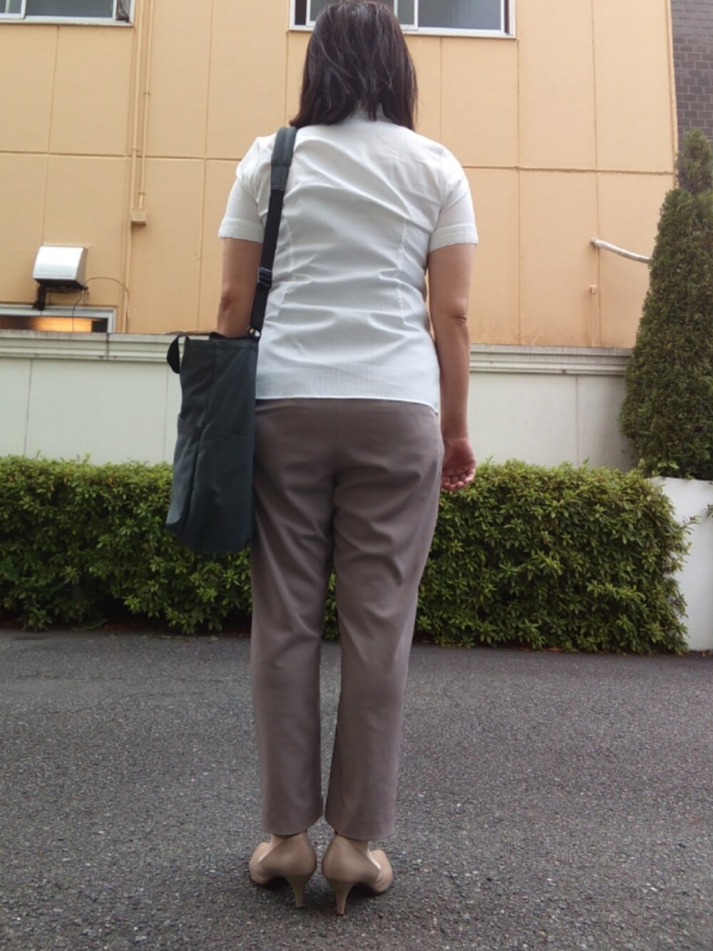 ホワイト系のTシャツ/カットソー、ベージュ系のスラックス、ベージュ系のパンプスを着用したレディースの夏コーディネートの2枚目の写真