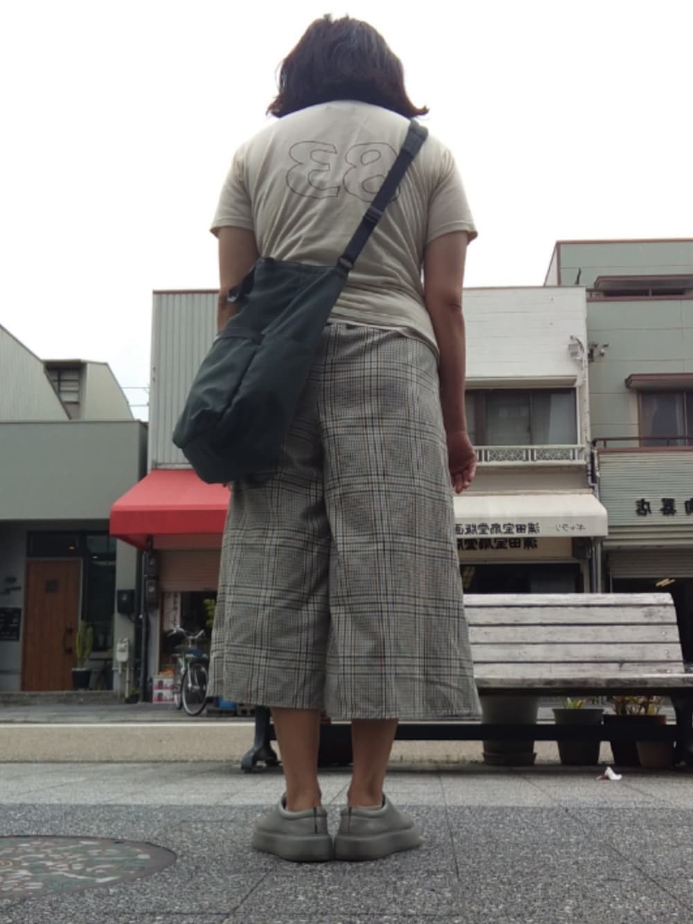 ベージュ系のTシャツ/カットソー、グレー系のスラックス、グレー系のスニーカーを着用したレディースの夏コーディネートの3枚目の写真