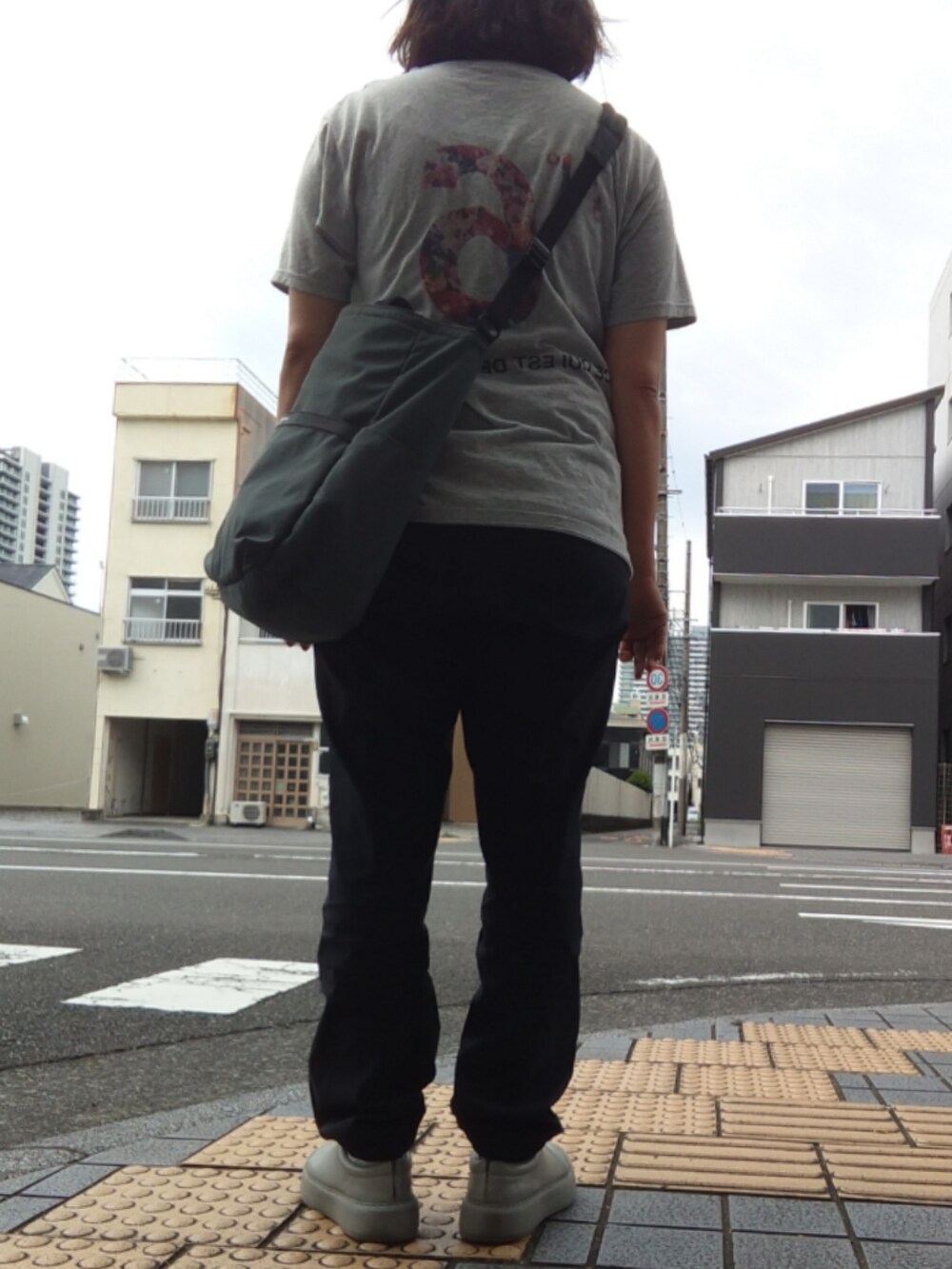 ブラック系のチノパンツを着用したレディースの夏コーディネートの2枚目の写真