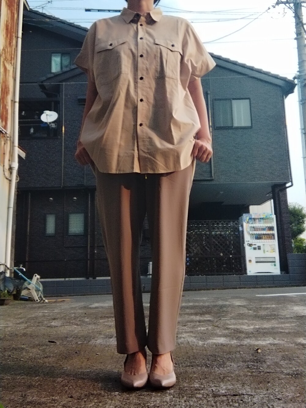 ベージュ系のスラックス、ベージュ系のパンプス、ベージュ系のシャツ/ブラウスを着用したレディースの夏コーディネートの2枚目の写真