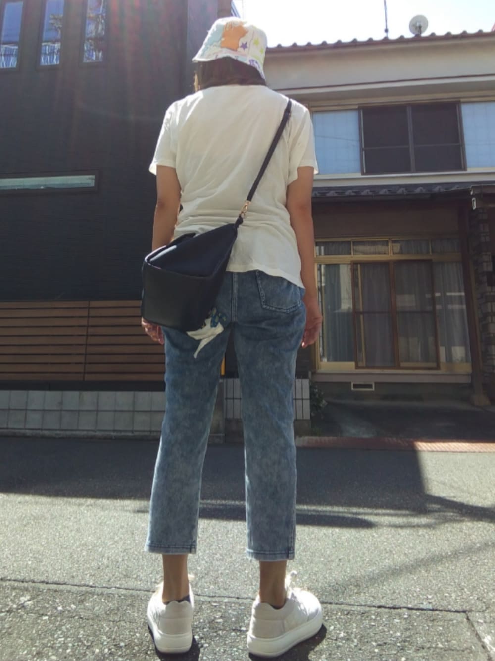 ホワイト系のスニーカー、ホワイト系のTシャツ/カットソー、ホワイト系のハットを着用したレディースの春コーディネートの2枚目の写真