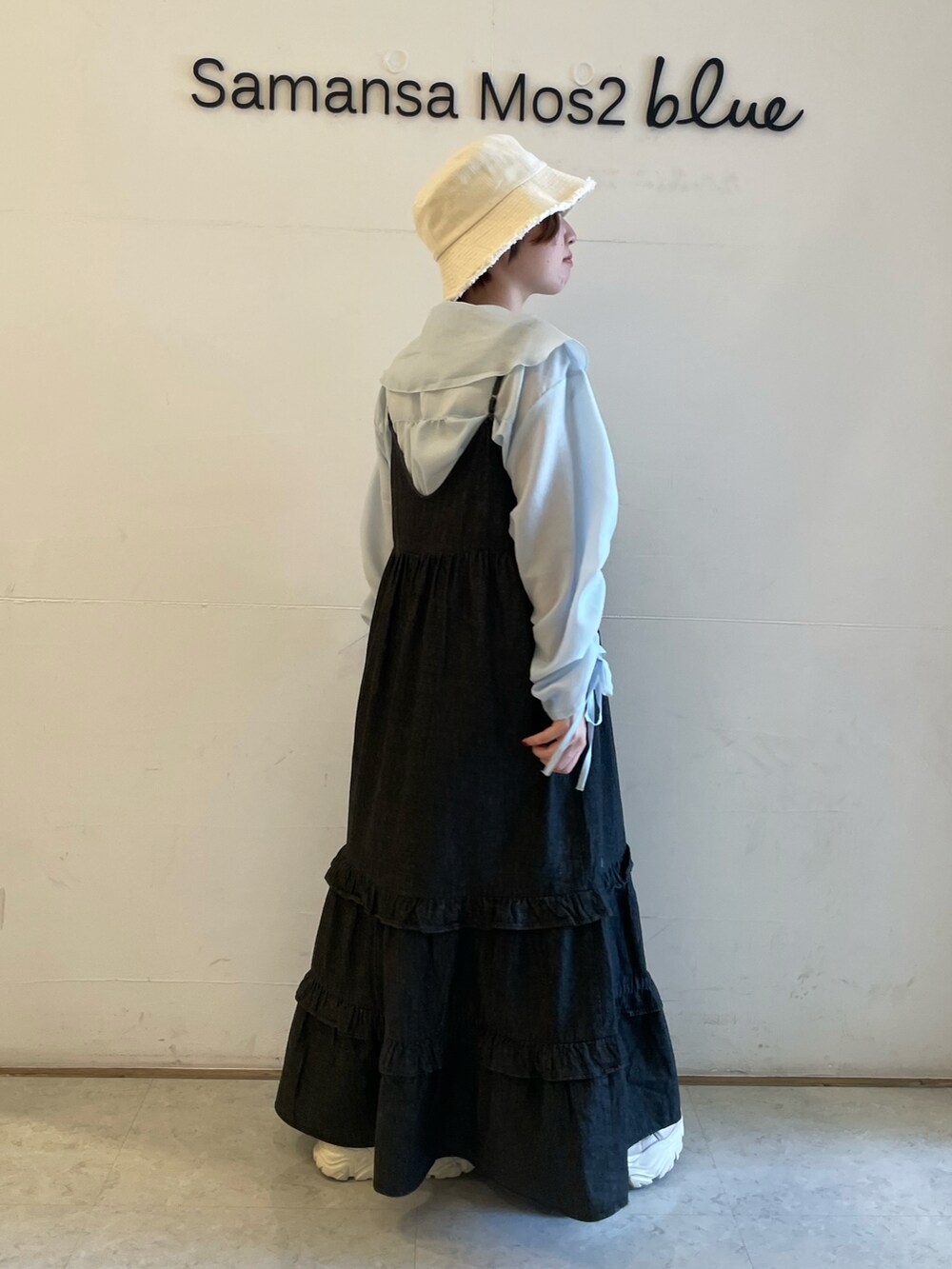 ブルー系のシャツ/ブラウス、ブラック系のワンピース、ベージュ系のスニーカーを着用したレディースの春コーディネートの2枚目の写真