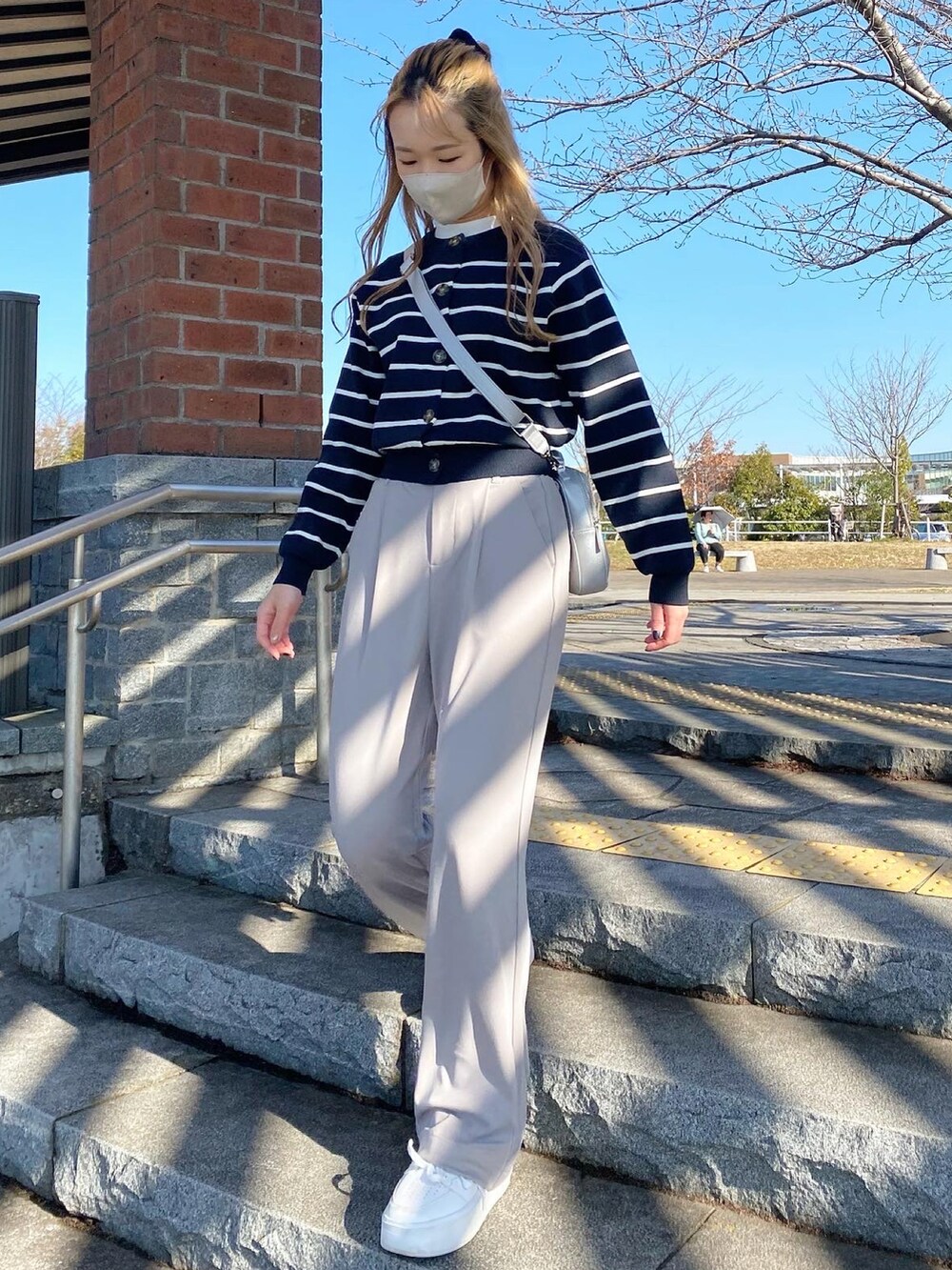 ブルー系のカーディガン/ボレロ、ホワイト系のTシャツ/カットソー、シルバー系のショルダーバッグを着用したレディースの冬コーディネートの2枚目の写真