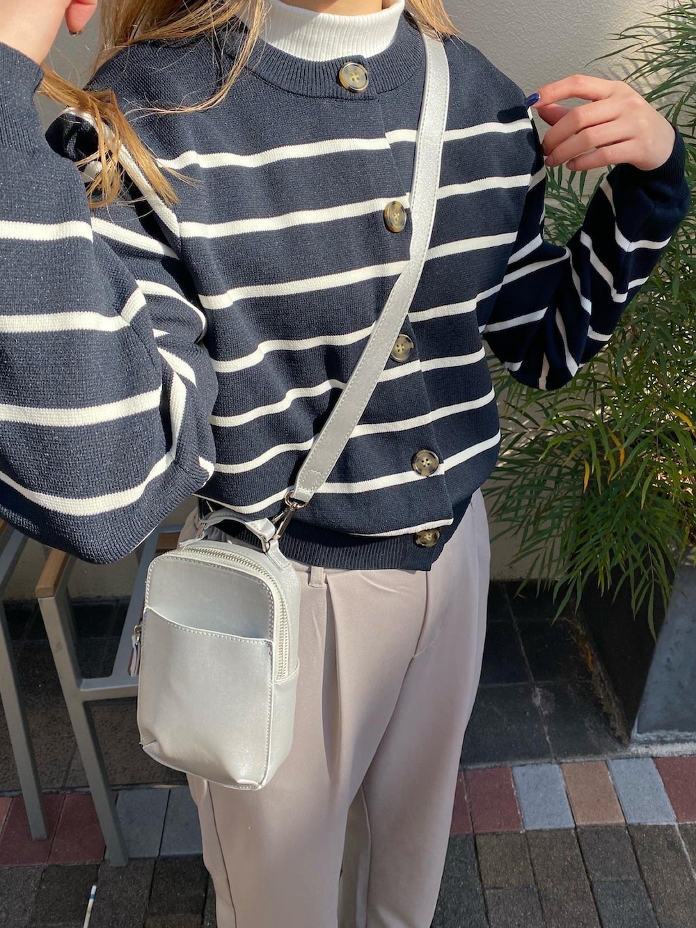 ブルー系のカーディガン/ボレロ、ホワイト系のTシャツ/カットソー、シルバー系のショルダーバッグを着用したレディースの冬コーディネートの3枚目の写真