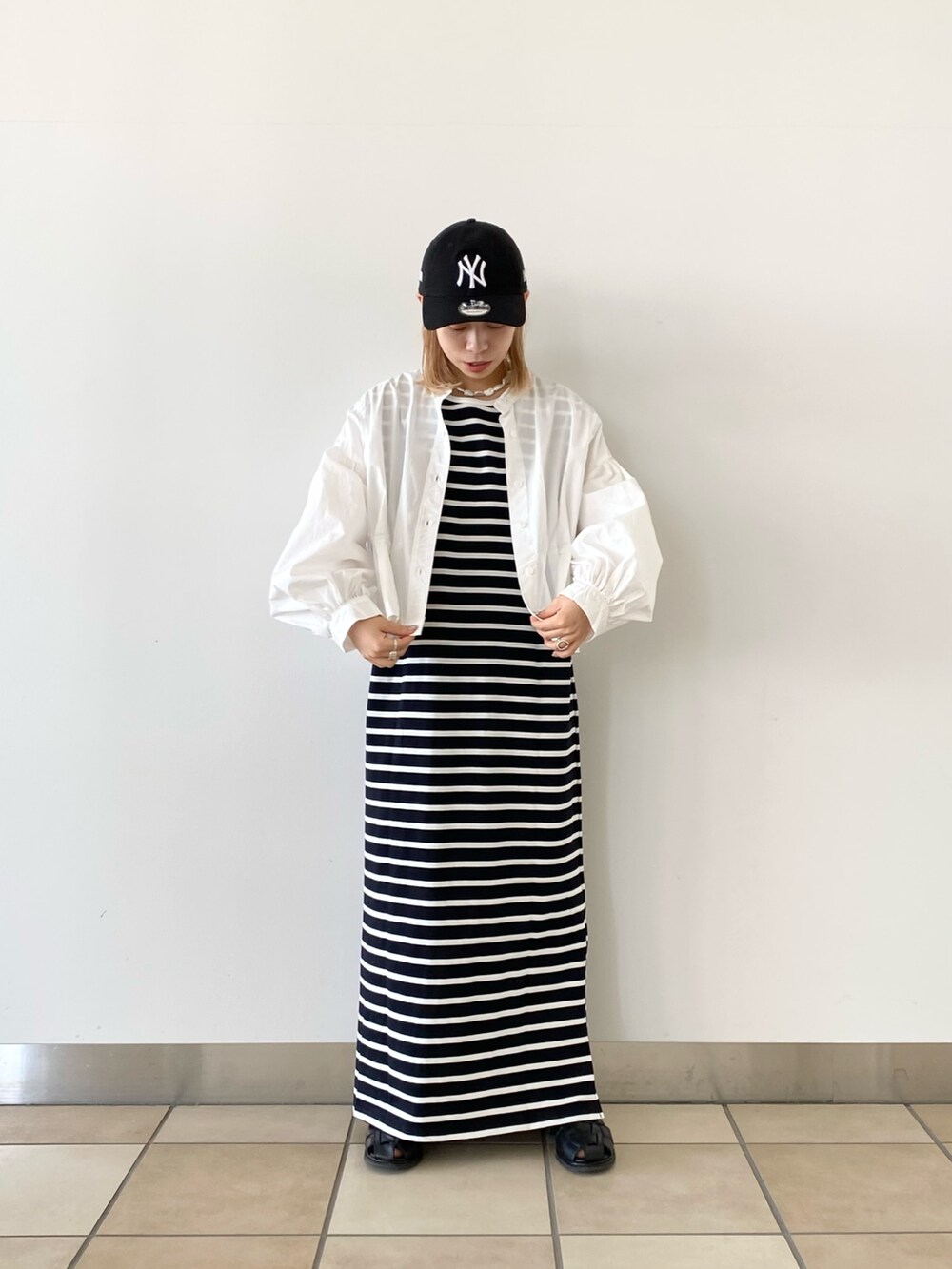 ブラック系のワンピース、ホワイト系のシャツ/ブラウスを着用したレディースの春コーディネートの2枚目の写真