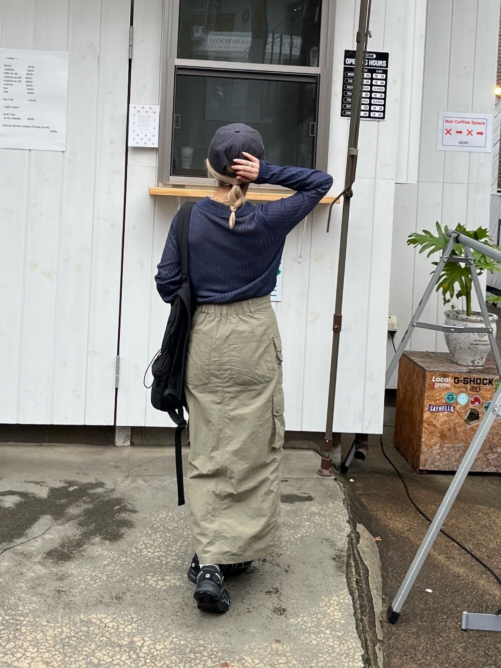 ブルー系のニット/セーター、グリーン系のスカート、グレー系のキャップを着用したレディースの春コーディネートの4枚目の写真