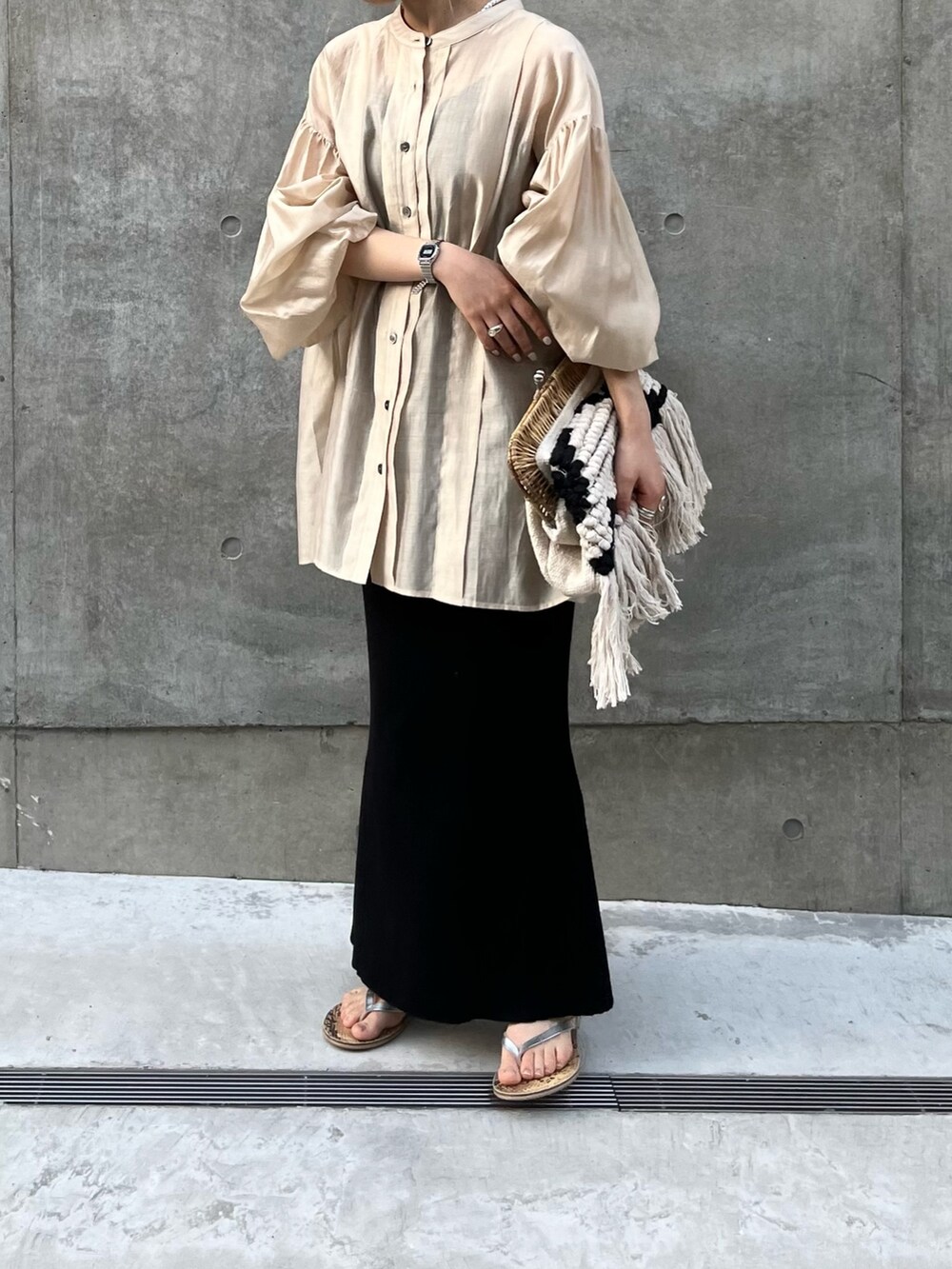 ベージュ系のシャツ/ブラウス、ブラック系のスカートを着用したレディースの春コーディネートの2枚目の写真