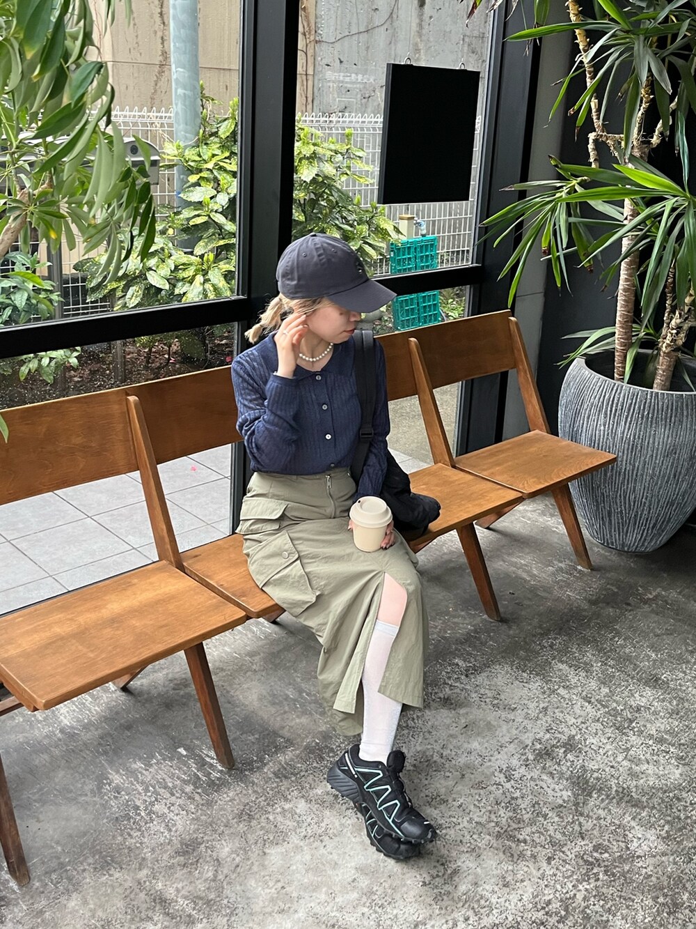 ブルー系のニット/セーター、グリーン系のスカート、グレー系のキャップを着用したレディースの春コーディネートの5枚目の写真