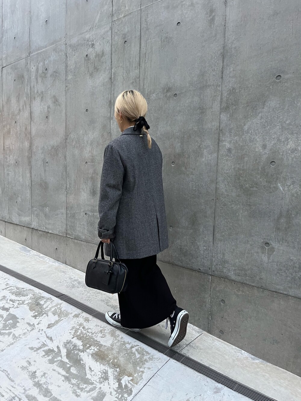 ブラック系のハンドバッグ、グレー系のテーラードジャケット、ブラック系のスカートを着用したレディースの冬コーディネートの5枚目の写真