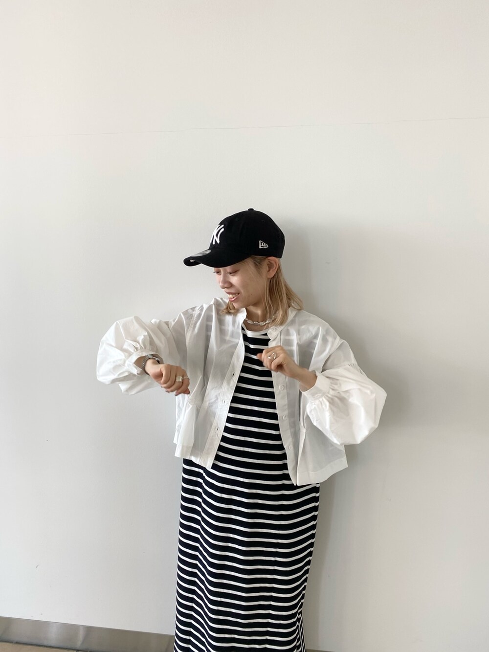 ブラック系のワンピース、ホワイト系のシャツ/ブラウスを着用したレディースの春コーディネートの3枚目の写真