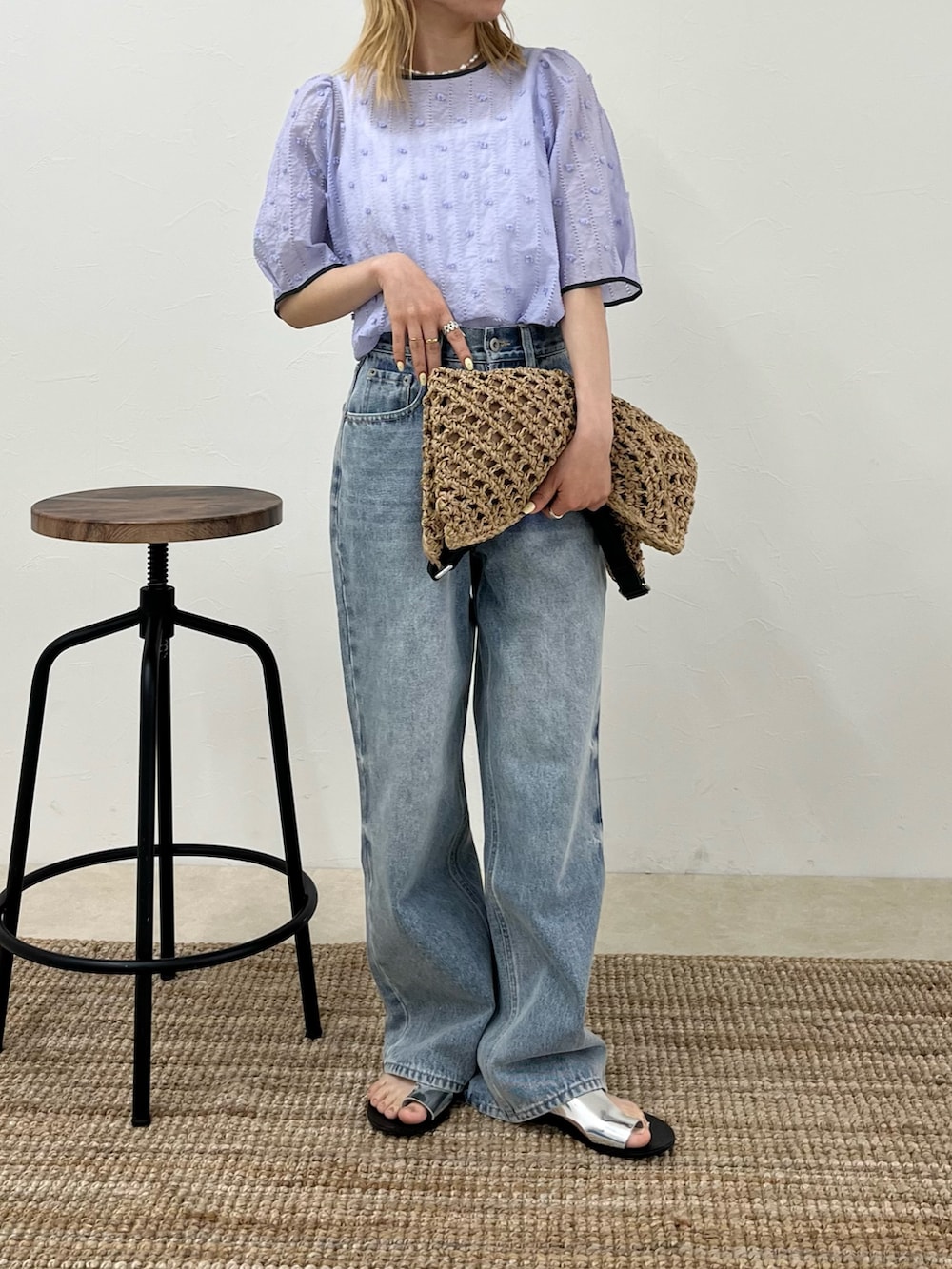 ブルー系のデニムパンツ、パープル系のシャツ/ブラウス、ベージュ系のショルダーバッグを着用したレディースの春コーディネートの3枚目の写真