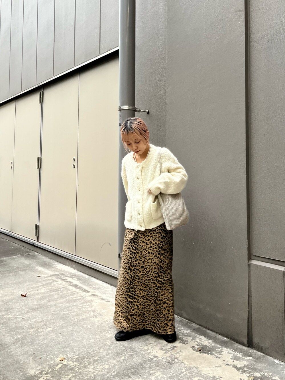 ベージュ系のスカート、ホワイト系のカーディガン/ボレロを着用したレディースの秋コーディネートの2枚目の写真