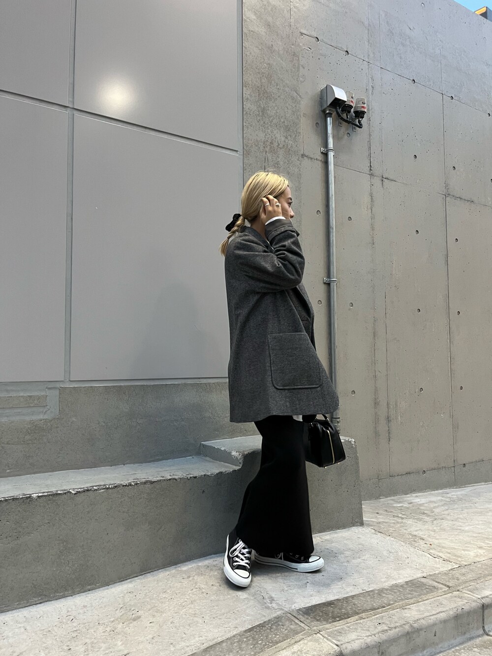 ブラック系のハンドバッグ、グレー系のテーラードジャケット、ブラック系のスカートを着用したレディースの冬コーディネートの3枚目の写真