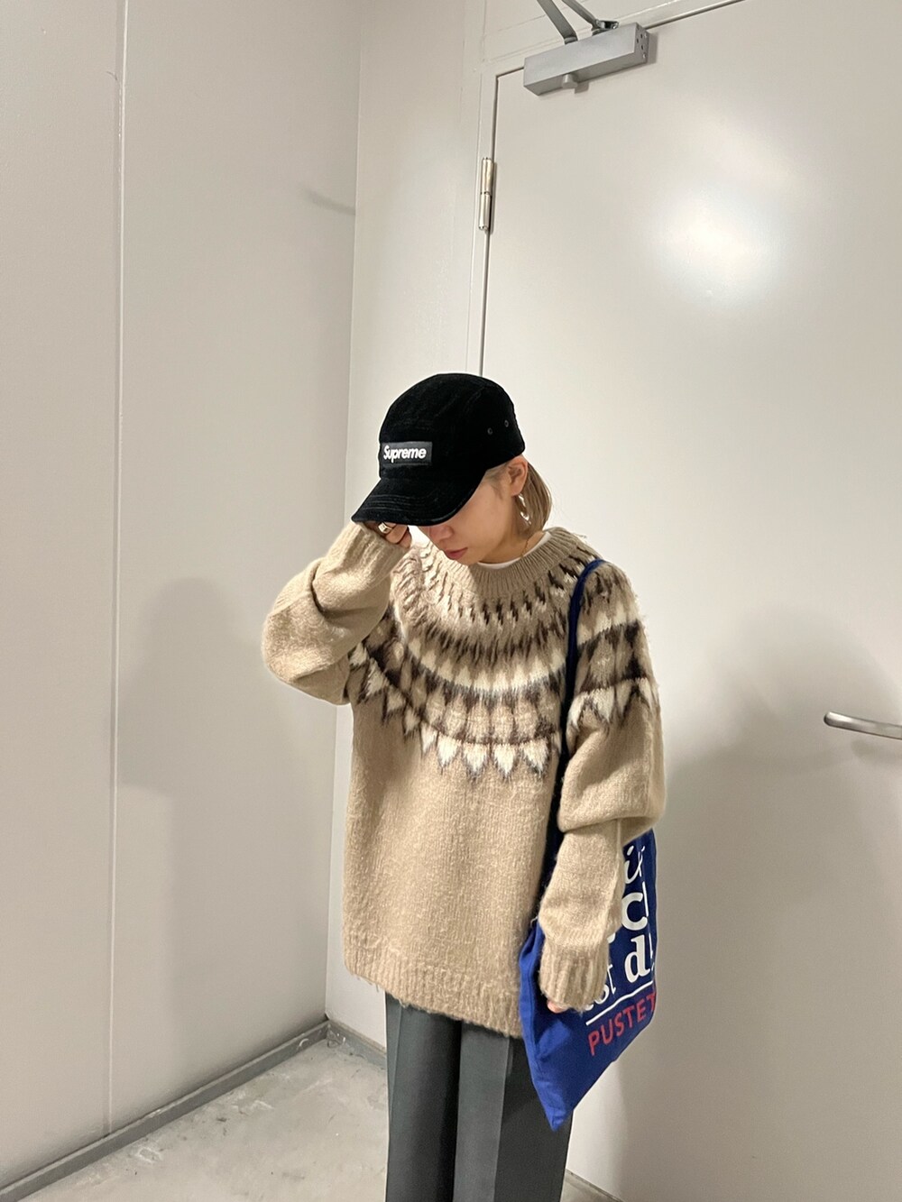 ベージュ系のニット/セーターを着用したレディースの冬コーディネートの2枚目の写真