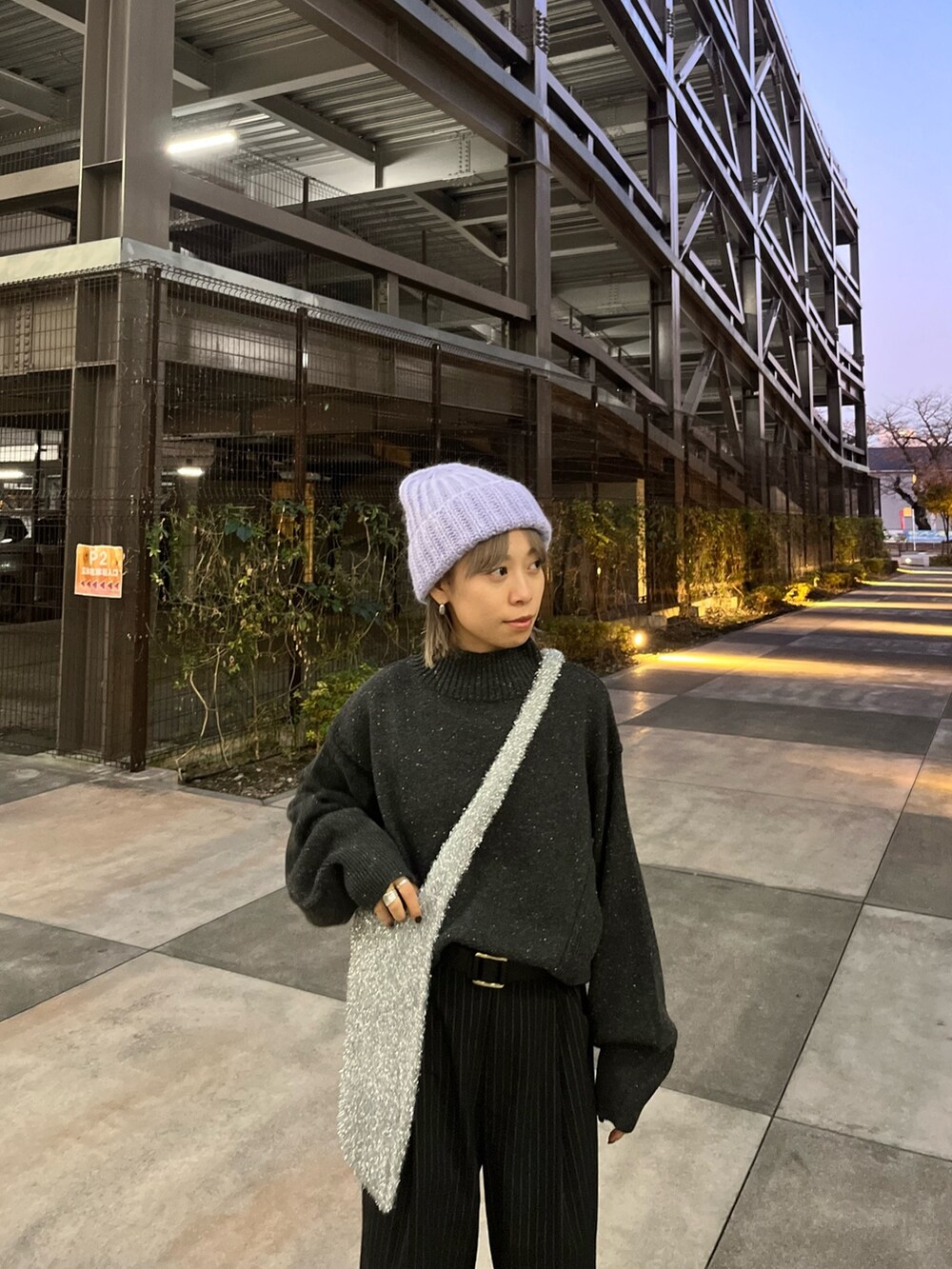 グレー系のニット/セーター、シルバー系のトートバッグを着用したレディースの冬コーディネートの2枚目の写真
