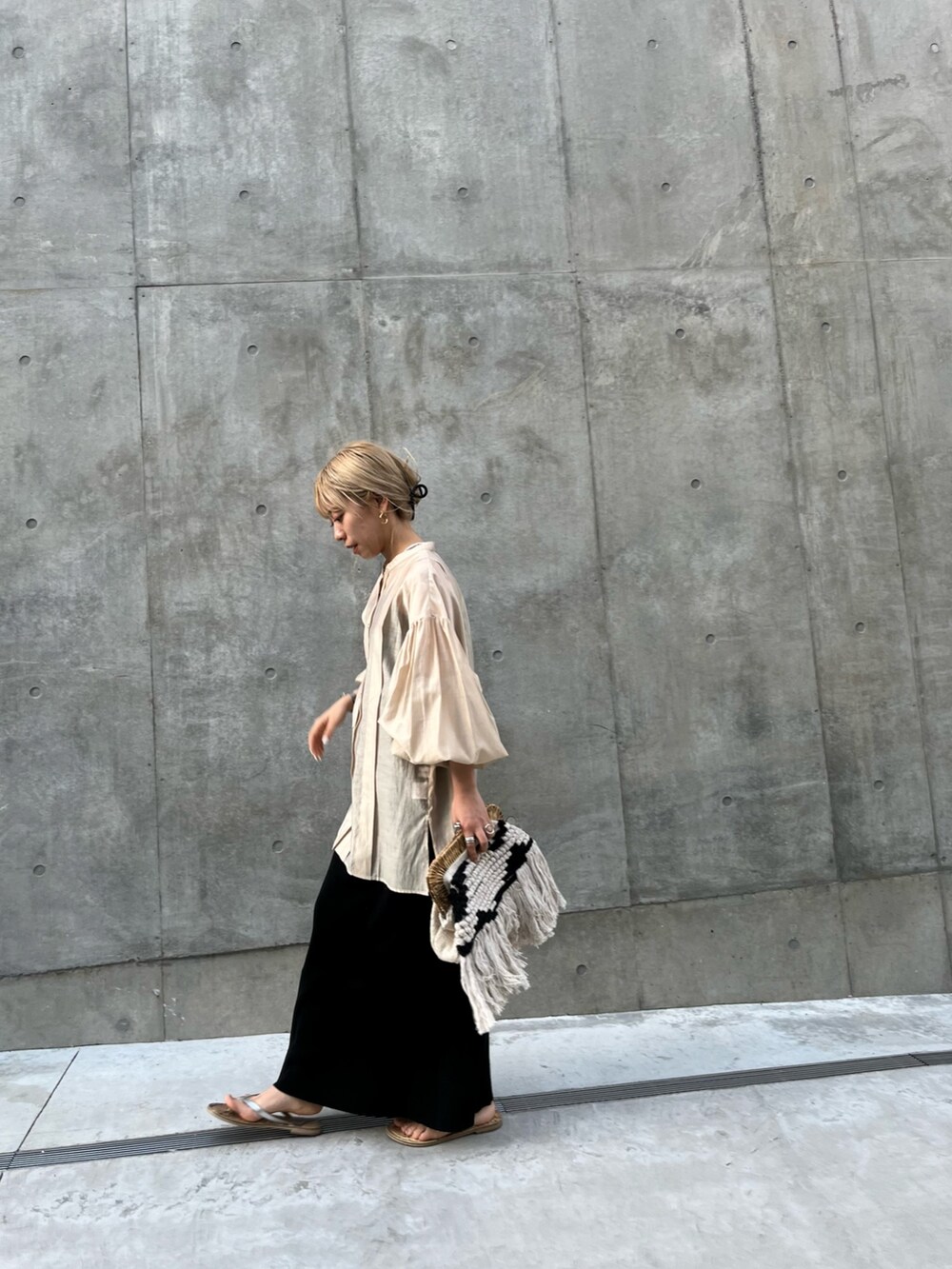 ベージュ系のシャツ/ブラウス、ブラック系のスカートを着用したレディースの春コーディネートの6枚目の写真