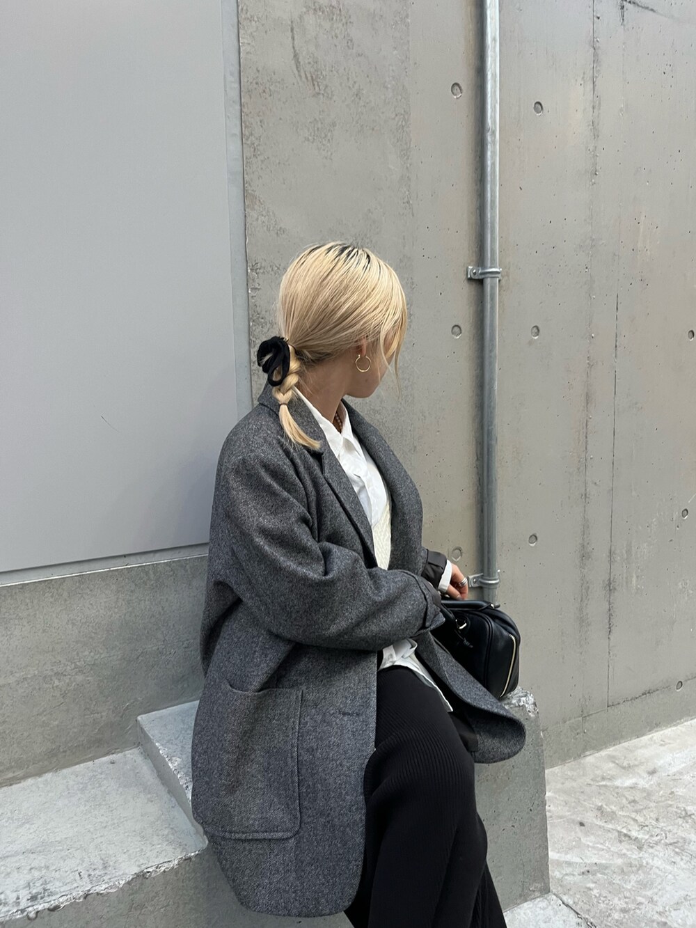ブラック系のハンドバッグ、グレー系のテーラードジャケット、ブラック系のスカートを着用したレディースの冬コーディネートの4枚目の写真