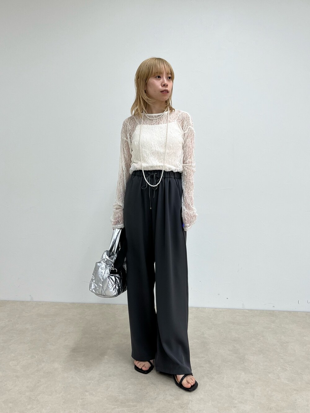 ホワイト系のTシャツ/カットソー、グレー系のその他パンツ、シルバー系のショルダーバッグを着用したレディースの春コーディネートの2枚目の写真