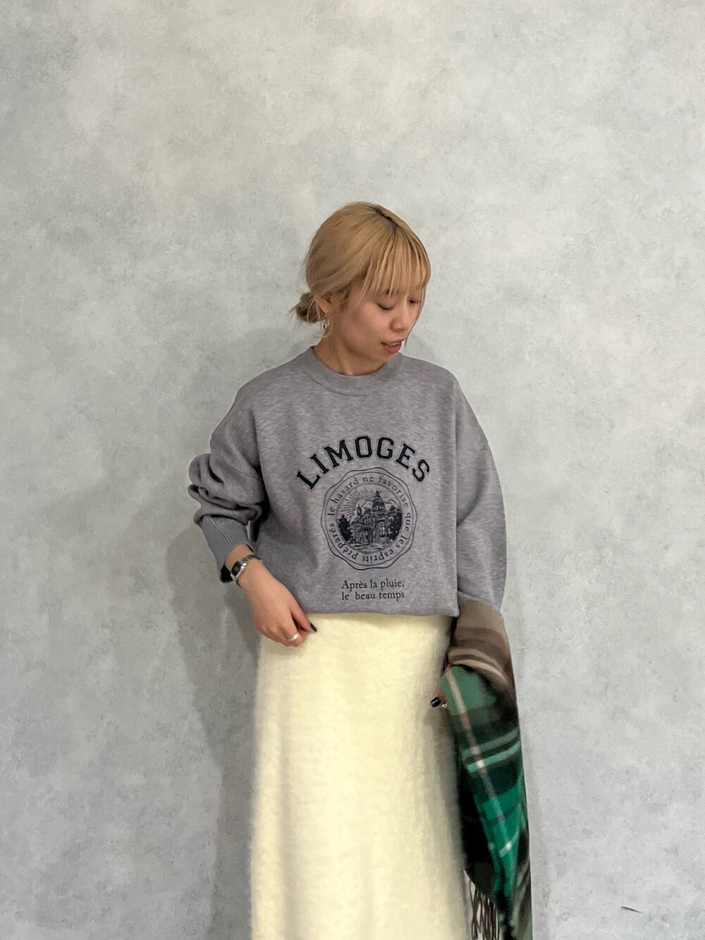 グレー系のニット/セーター、ホワイト系のスカート、グリーン系のストール/ショールを着用したレディースの冬コーディネートの5枚目の写真