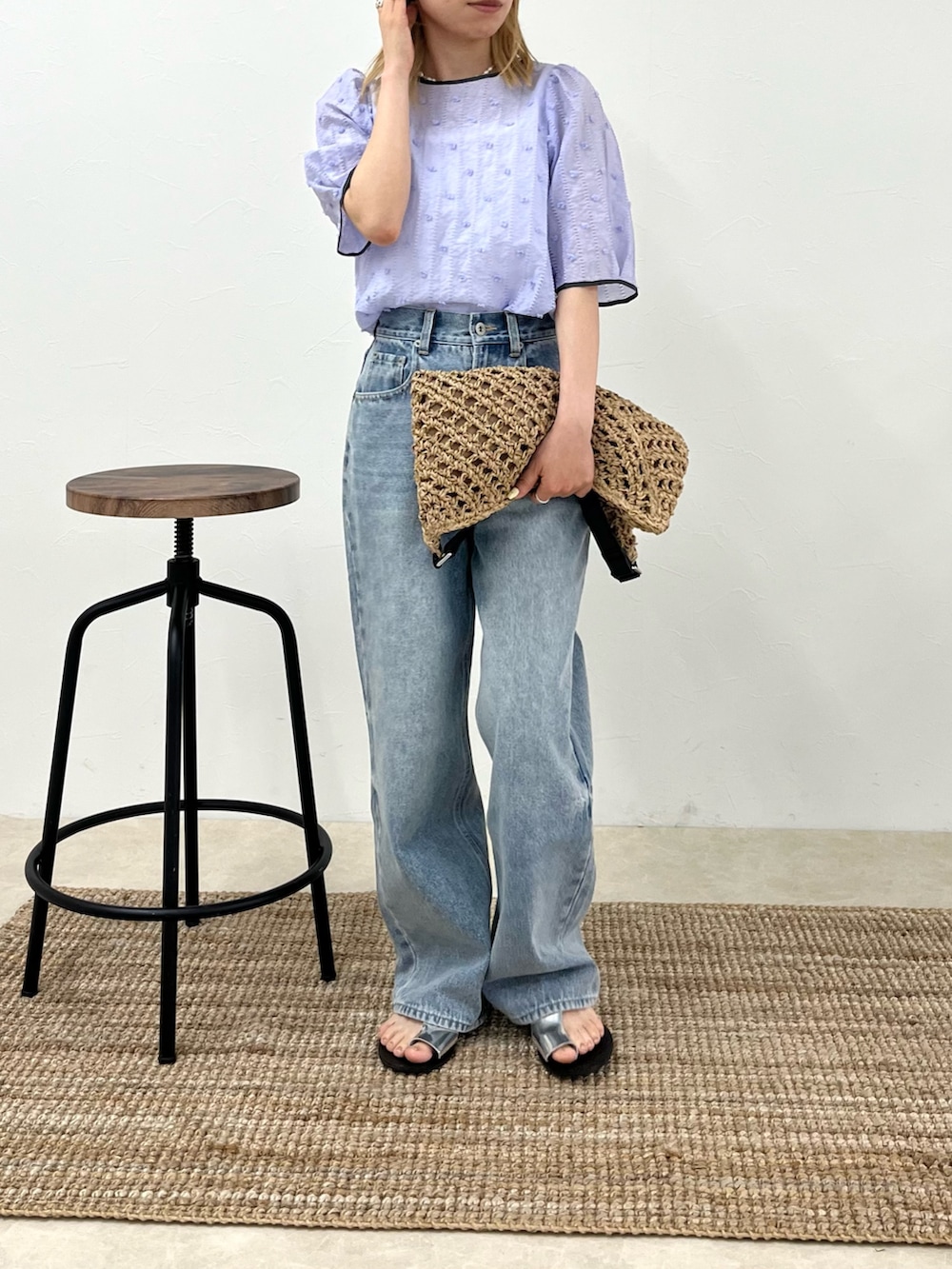 ブルー系のデニムパンツ、パープル系のシャツ/ブラウス、ベージュ系のショルダーバッグを着用したレディースの春コーディネートの2枚目の写真