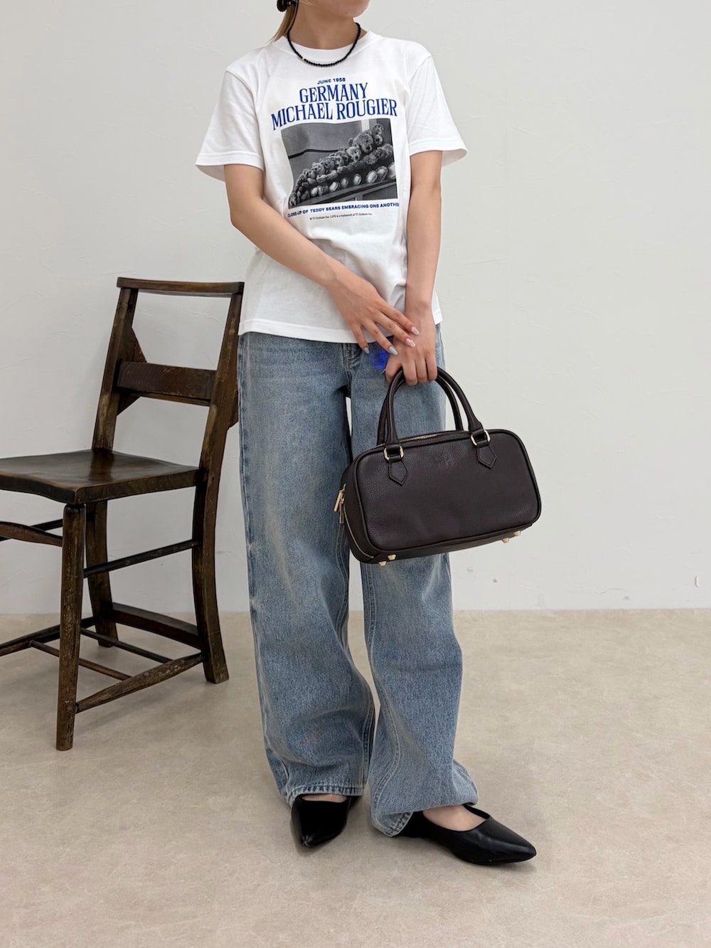 ホワイト系のTシャツ/カットソー、ブラック系のボストンバッグ、ブルー系のデニムパンツを着用したレディースの夏コーディネートの2枚目の写真
