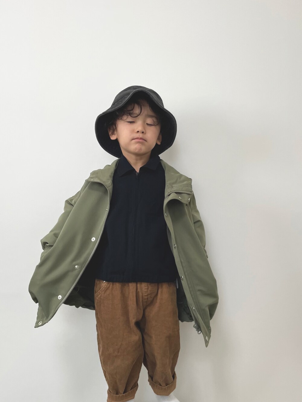 グリーン系のモッズコート、ブラウン系のパンツ、ブラック系のシャツ/ブラウスを着用したキッズの冬コーディネートの3枚目の写真