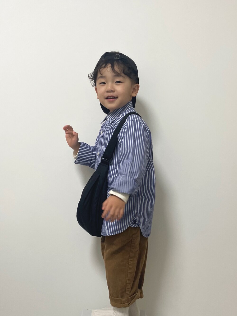 ブルー系のシャツ/ブラウス、ブラウン系のパンツ、ブラック系のボディバッグ/ウエストポーチを着用したキッズの春コーディネートの2枚目の写真