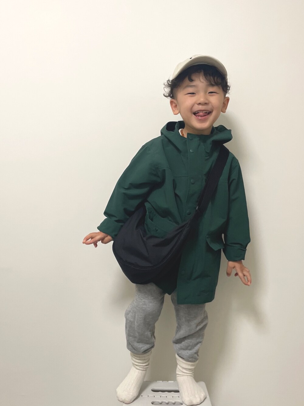 ブラック系のボディバッグ/ウエストポーチ、グリーン系のジャケット/アウター、グレー系のスウェットパンツを着用したキッズの冬コーディネートの2枚目の写真