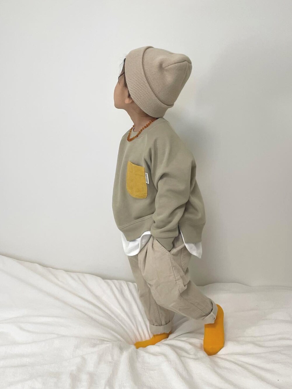 ベージュ系のパンツ、ブルー系のデニムジャケット、ベージュ系のスウェットを着用したキッズの冬コーディネートの2枚目の写真