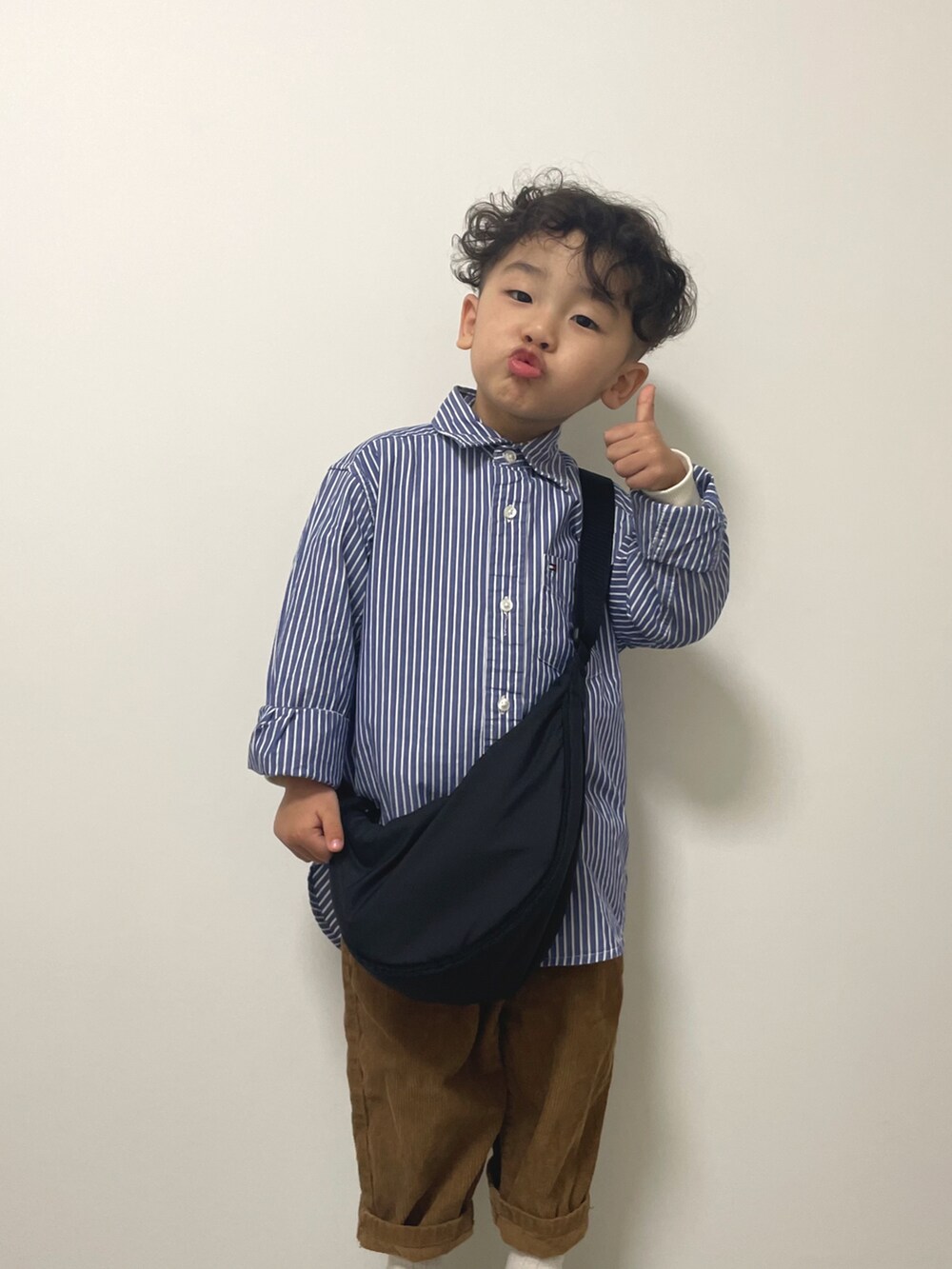 ブルー系のシャツ/ブラウス、ブラウン系のパンツ、ブラック系のボディバッグ/ウエストポーチを着用したキッズの春コーディネートの3枚目の写真