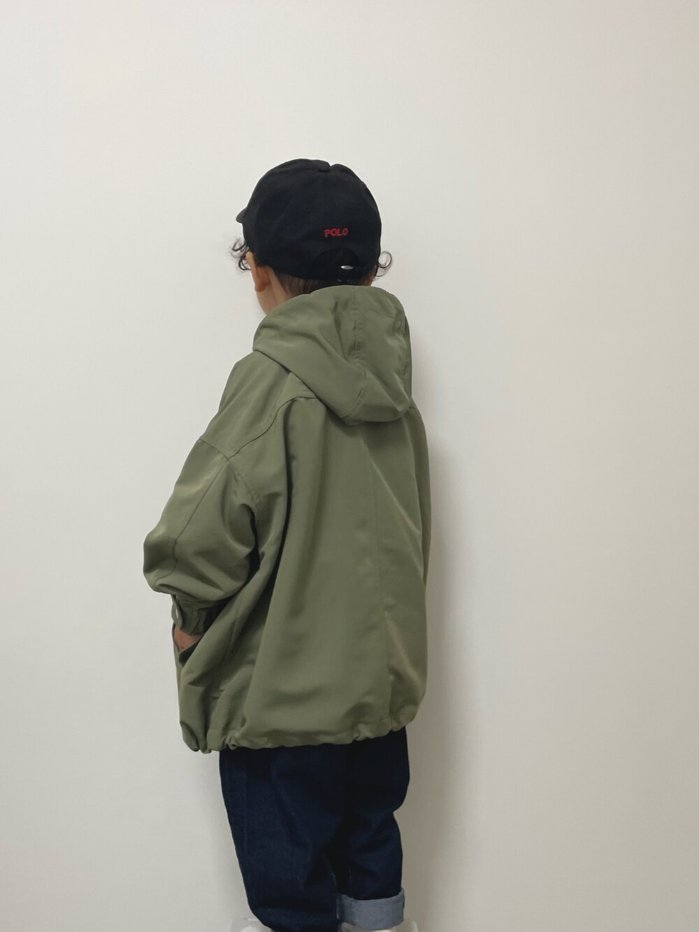 ホワイト系のスウェット、ブルー系のデニムパンツ、グリーン系のモッズコートを着用したキッズの冬コーディネートの2枚目の写真