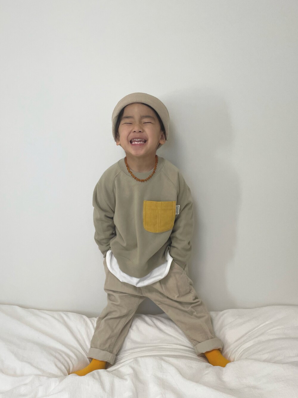 ベージュ系のパンツ、ブルー系のデニムジャケット、ベージュ系のスウェットを着用したキッズの冬コーディネートの3枚目の写真