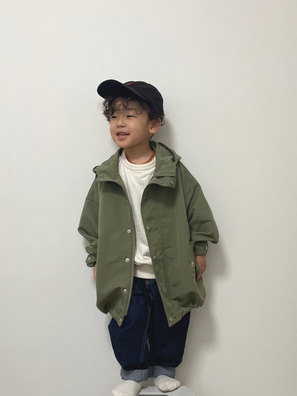 ホワイト系のスウェット、ブルー系のデニムパンツ、グリーン系のモッズコートを着用したキッズの冬コーディネートの3枚目の写真