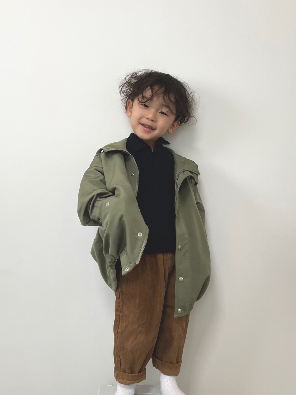 グリーン系のモッズコート、ブラウン系のパンツ、ブラック系のシャツ/ブラウスを着用したキッズの冬コーディネートの2枚目の写真