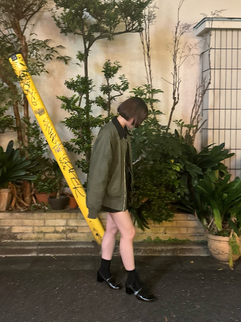 グリーン系のジャケット/アウター、ブラック系のスカートを着用したレディースの冬コーディネートの2枚目の写真