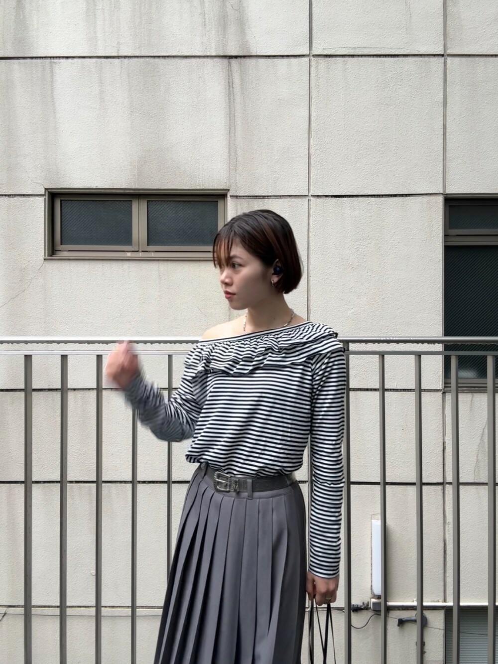 ブラック系のトップス、グレー系のスカートを着用したレディースの秋コーディネートの2枚目の写真