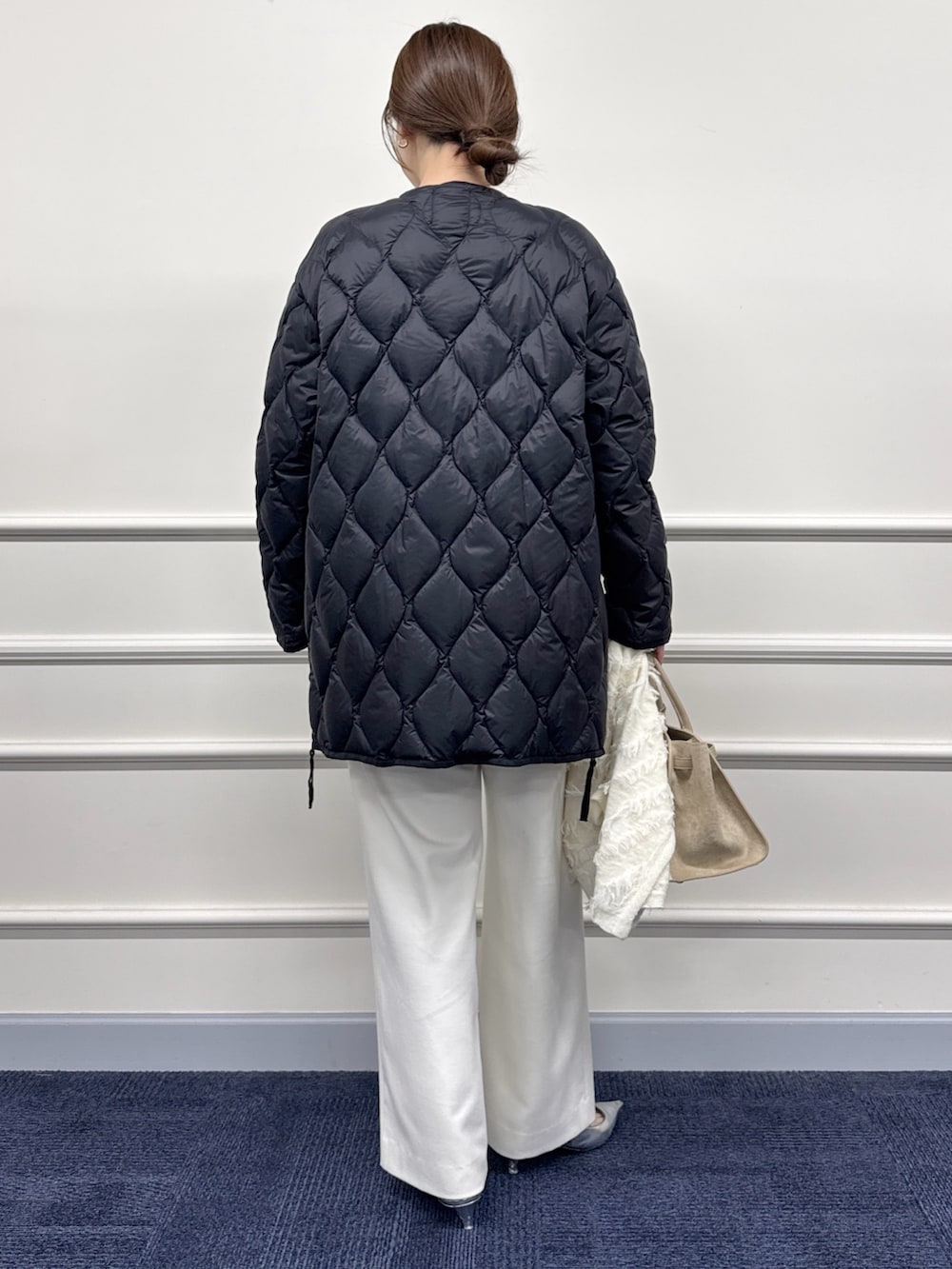 ホワイト系のその他パンツ、ブラウン系のトートバッグ、ブラック系のダウンジャケット/コートを着用したレディースの秋コーディネートの9枚目の写真