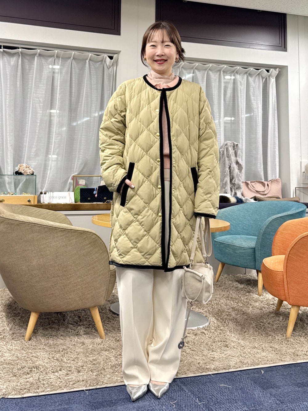 ベージュ系のショルダーバッグ、ベージュ系のダウンジャケット/コートを着用したレディースの秋コーディネートの4枚目の写真