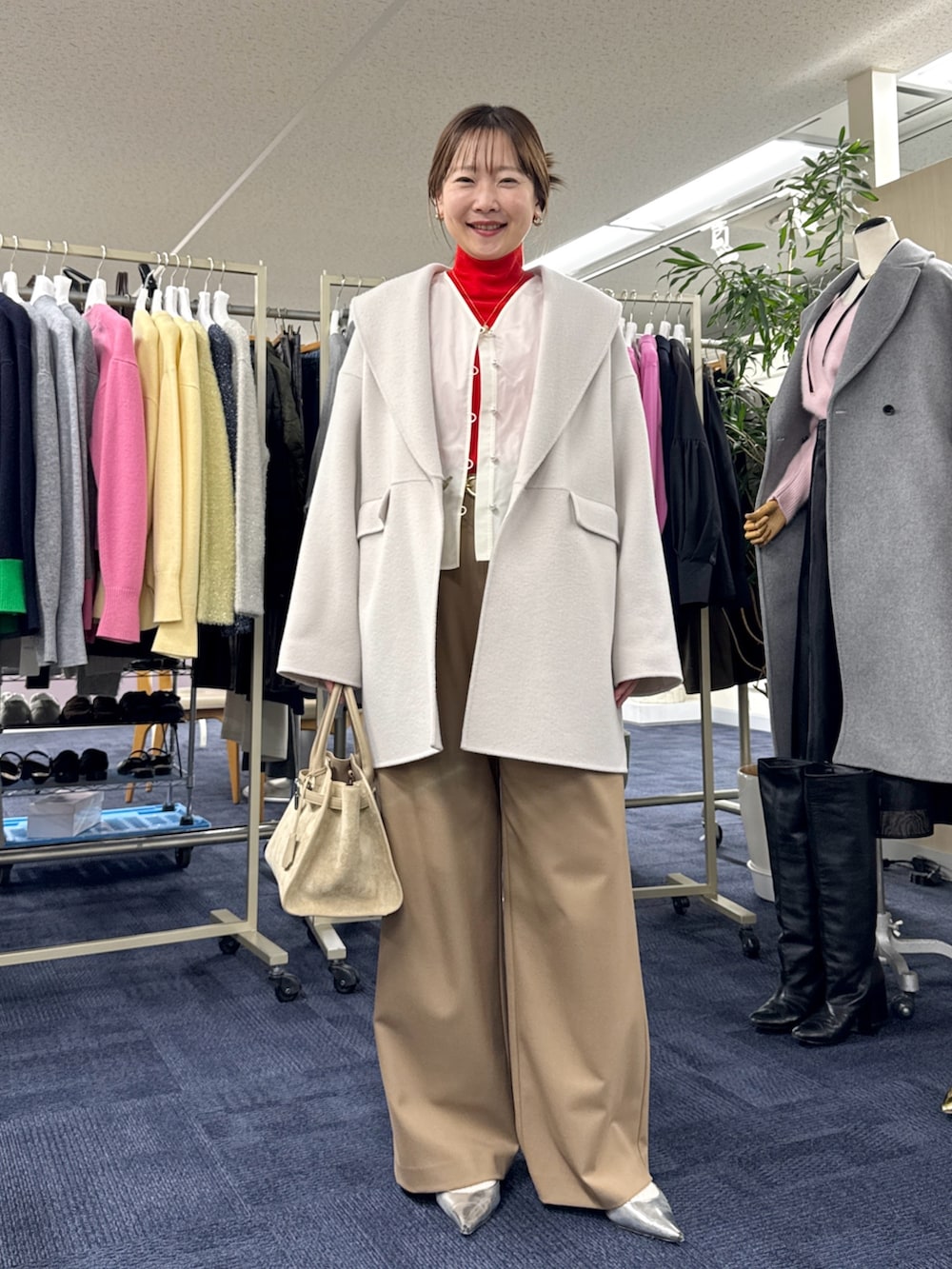 ベージュ系のその他アウター、ホワイト系のシャツ/ブラウス、レッド系のニット/セーターを着用したレディースの秋コーディネートの2枚目の写真