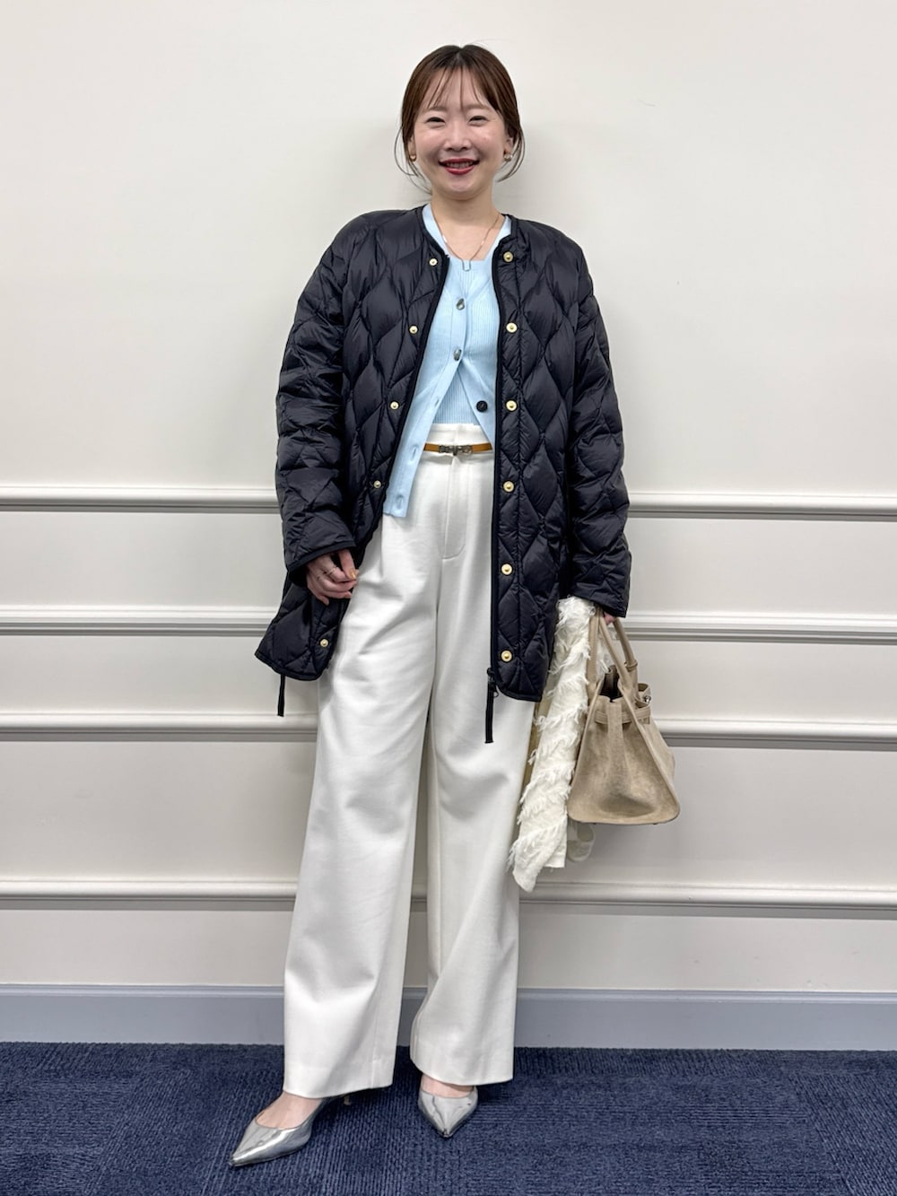 ホワイト系のその他パンツ、ブラウン系のトートバッグ、ブラック系のダウンジャケット/コートを着用したレディースの秋コーディネートの7枚目の写真