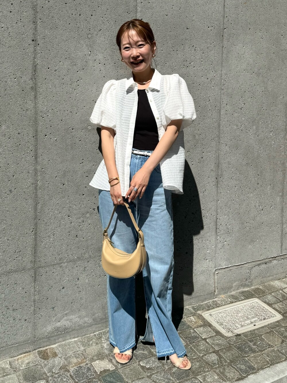 ホワイト系のシャツ/ブラウス、ベージュ系のショルダーバッグ、ブルー系のデニムパンツを着用したレディースの夏コーディネートの4枚目の写真