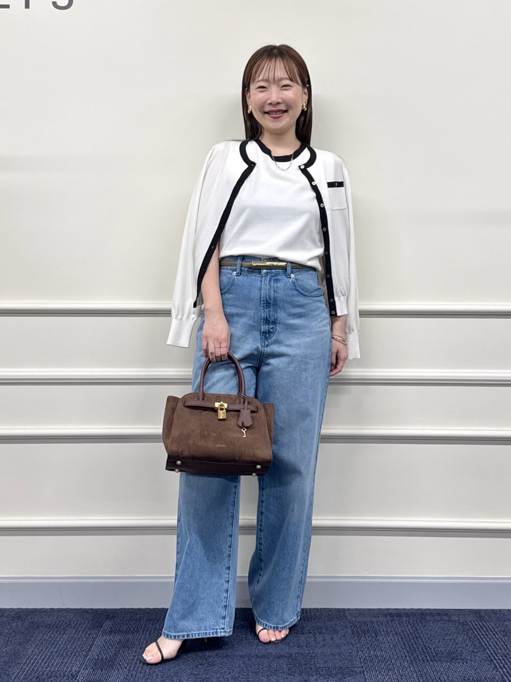 ブルー系のデニムパンツ、ブラウン系のトートバッグ、ホワイト系のカーディガン/ボレロを着用したレディースの夏コーディネートの5枚目の写真