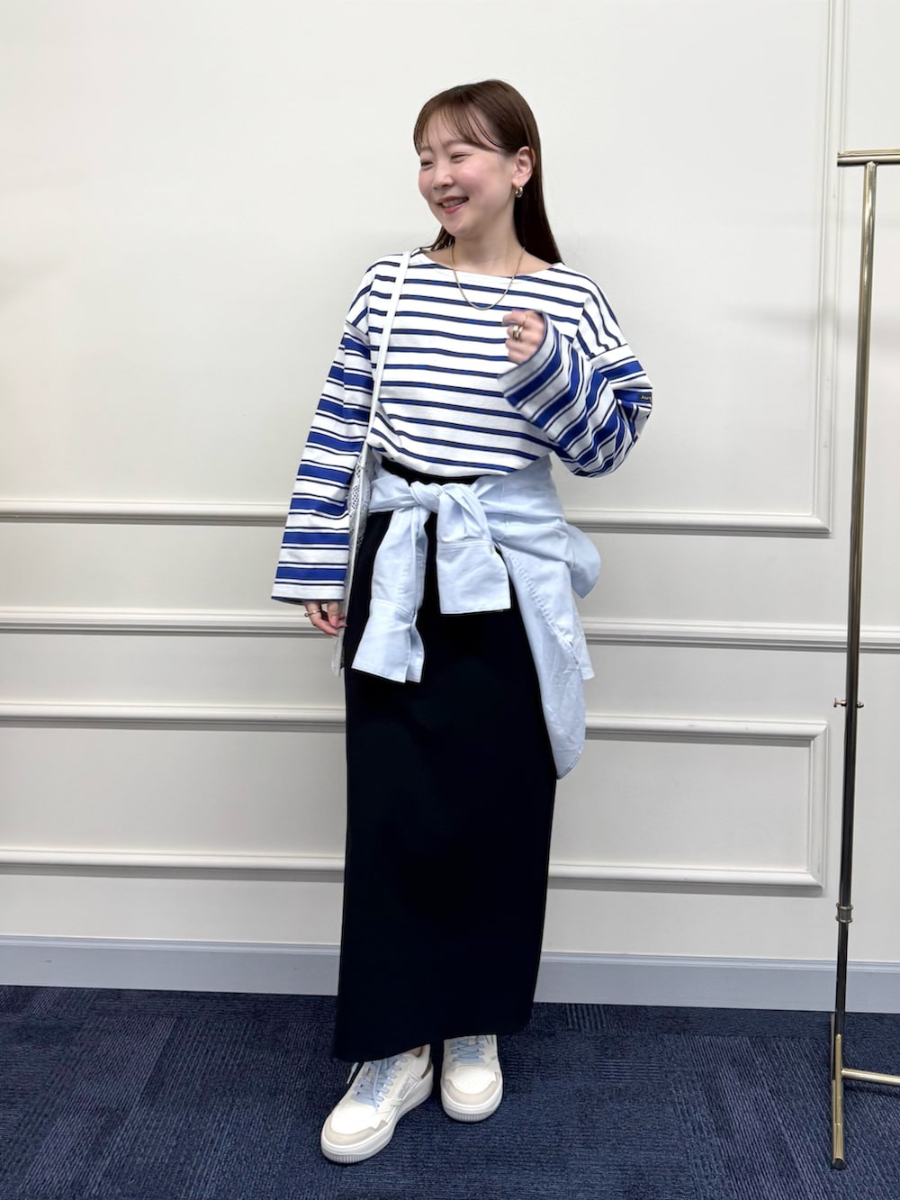 ブラック系のスカート、ブルー系のシャツ/ブラウス、ブルー系のTシャツ/カットソーを着用したレディースの春コーディネートの3枚目の写真