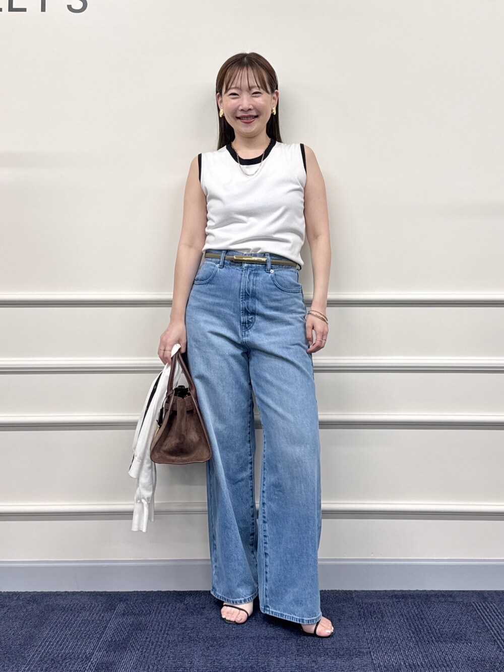 ブルー系のデニムパンツ、ブラウン系のトートバッグ、ホワイト系のカーディガン/ボレロを着用したレディースの夏コーディネートの7枚目の写真