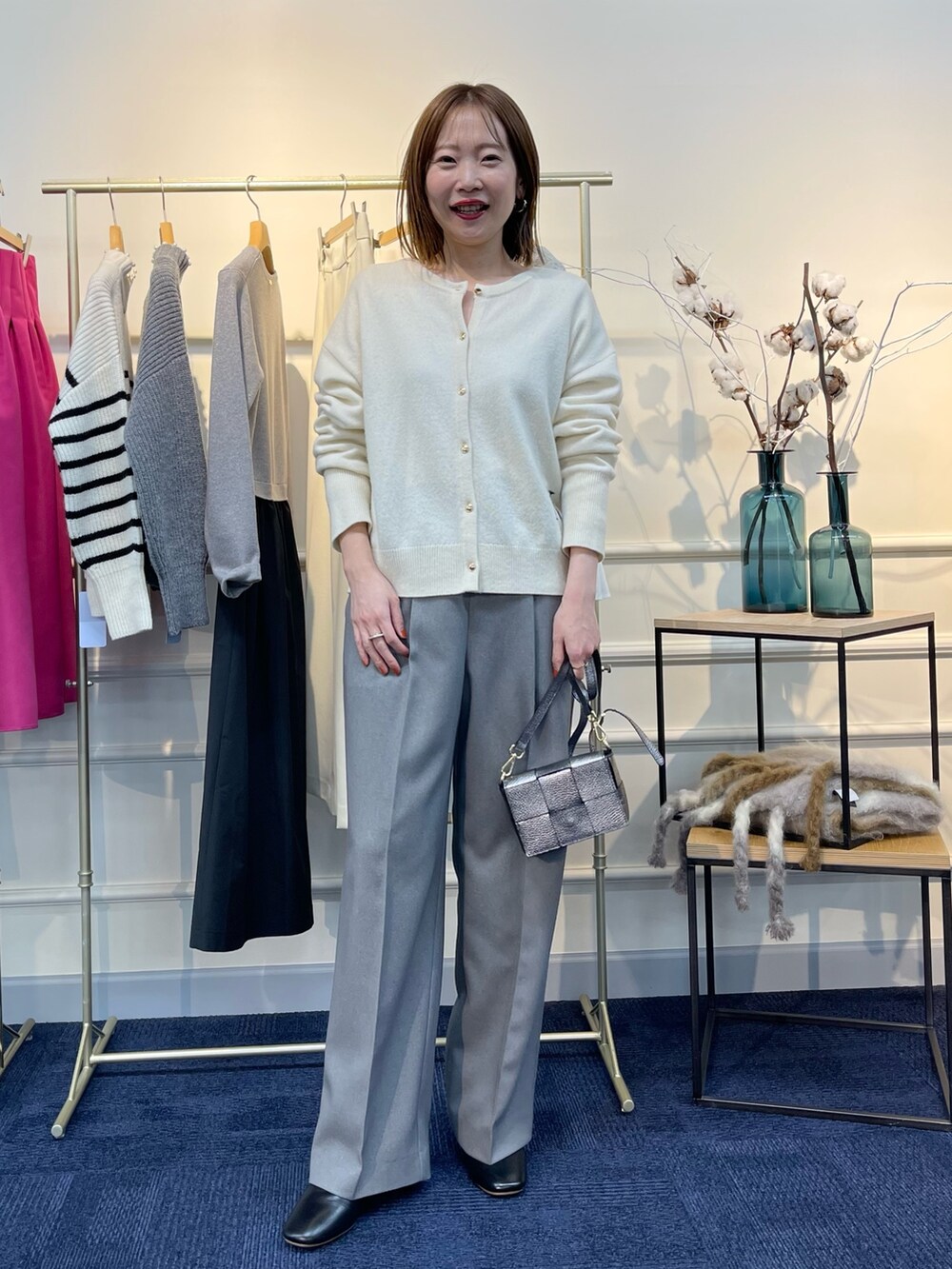 ホワイト系のカーディガン/ボレロ、ブラック系のブーツ、その他のショルダーバッグを着用したレディースの秋コーディネートの2枚目の写真