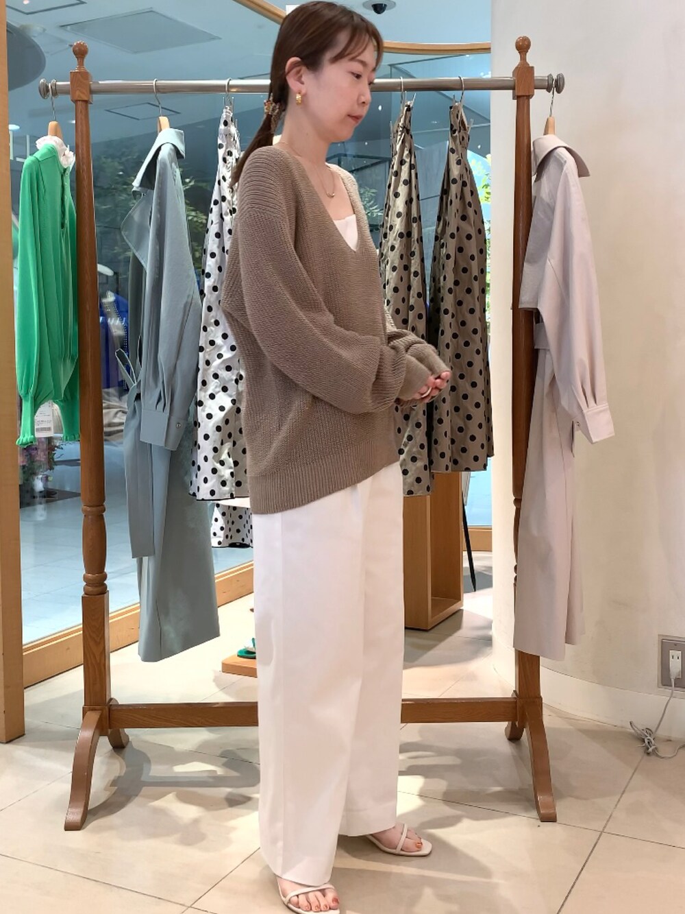 ベージュ系のニット/セーター、ホワイト系のキャミソール、ホワイト系のその他パンツを着用したレディースの春コーディネートの3枚目の写真