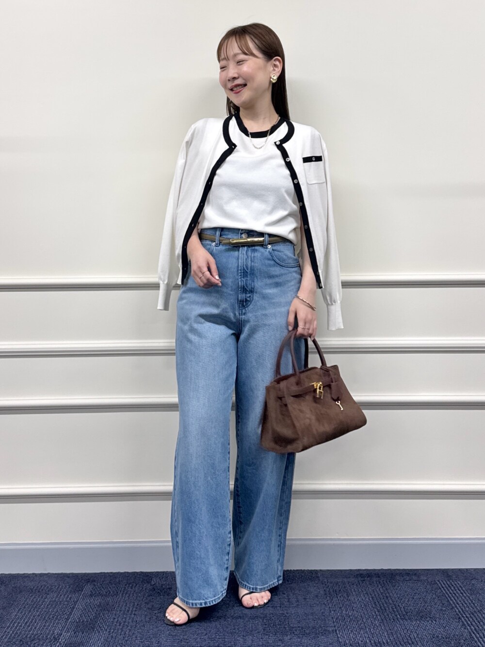 ブルー系のデニムパンツ、ブラウン系のトートバッグ、ホワイト系のカーディガン/ボレロを着用したレディースの夏コーディネートの6枚目の写真