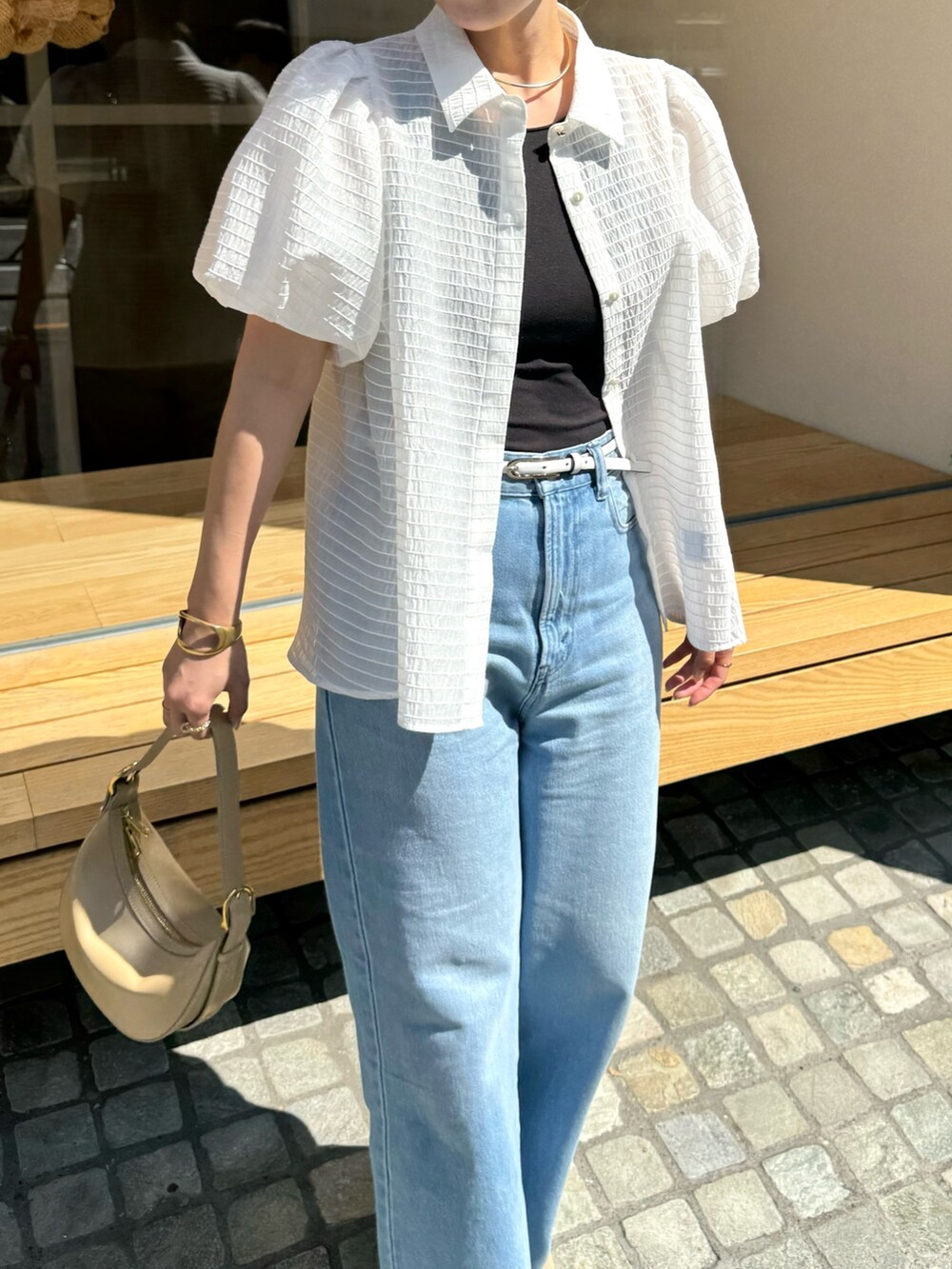 ホワイト系のシャツ/ブラウス、ベージュ系のショルダーバッグ、ブルー系のデニムパンツを着用したレディースの夏コーディネートの9枚目の写真